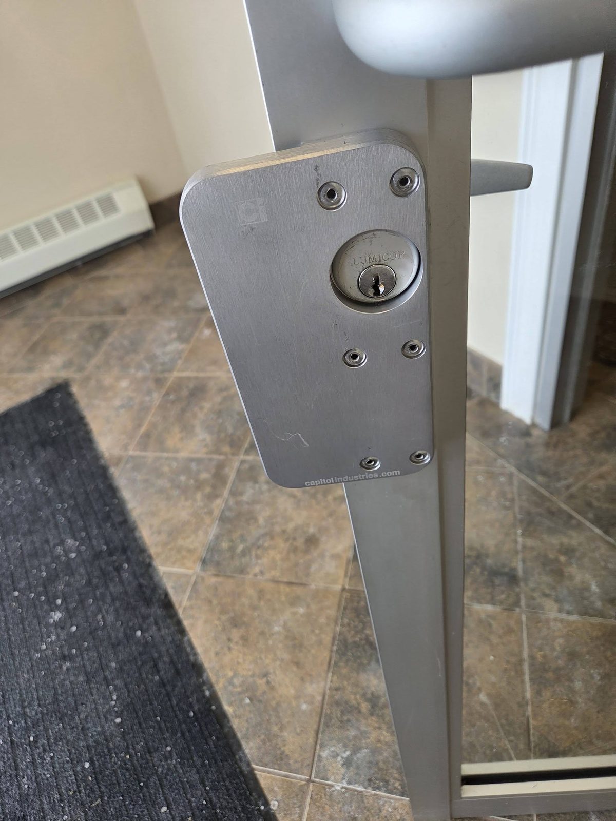 Commercial lock cylinder installed on an aluminum storefront door
